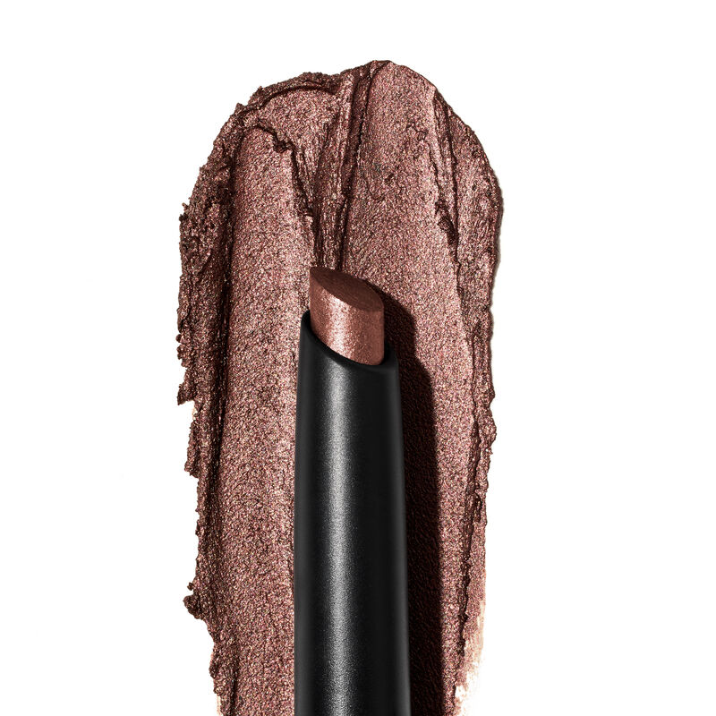 A product rub showing off the Radiant Bronze shade, finish and texture appears on a white surface with the uncapped product in front of it.&nbsp;