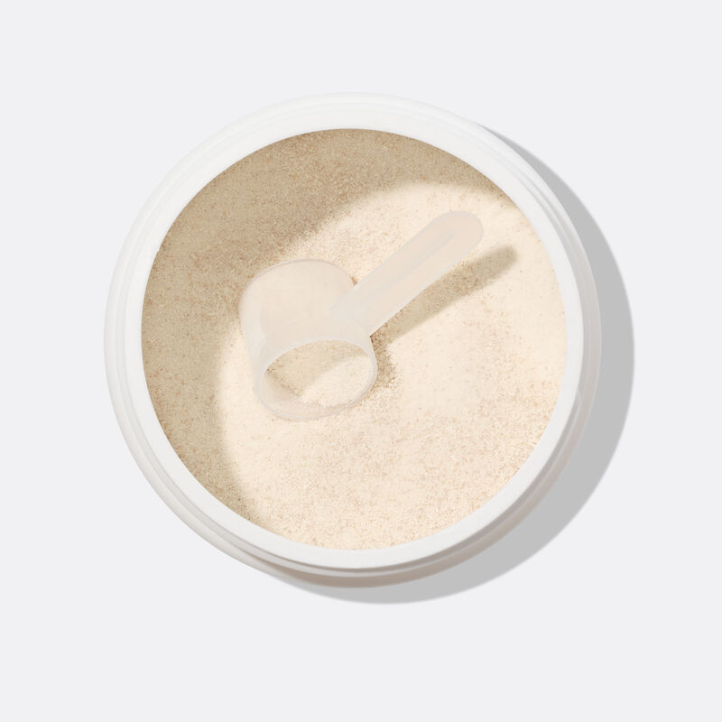 Nahaufnahme von L&ouml;ffel mit Pulver in Dose auf wei&szlig;em Grund.