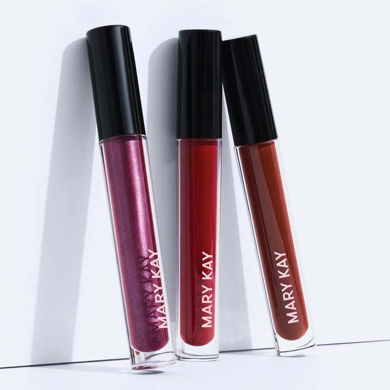 All three lip gloss shades, including Lilac Love, standing upright with caps on white surface.&nbsp;