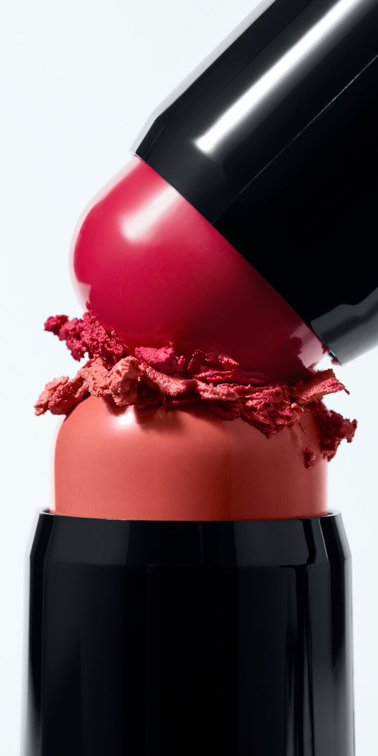 Zwei Blush Sticks von Mary Kay (Kind Spirit und Spark Change, in Rot und Korallrot) werden aufeinander gepresst, sodass Farbpigment abgerieben wird