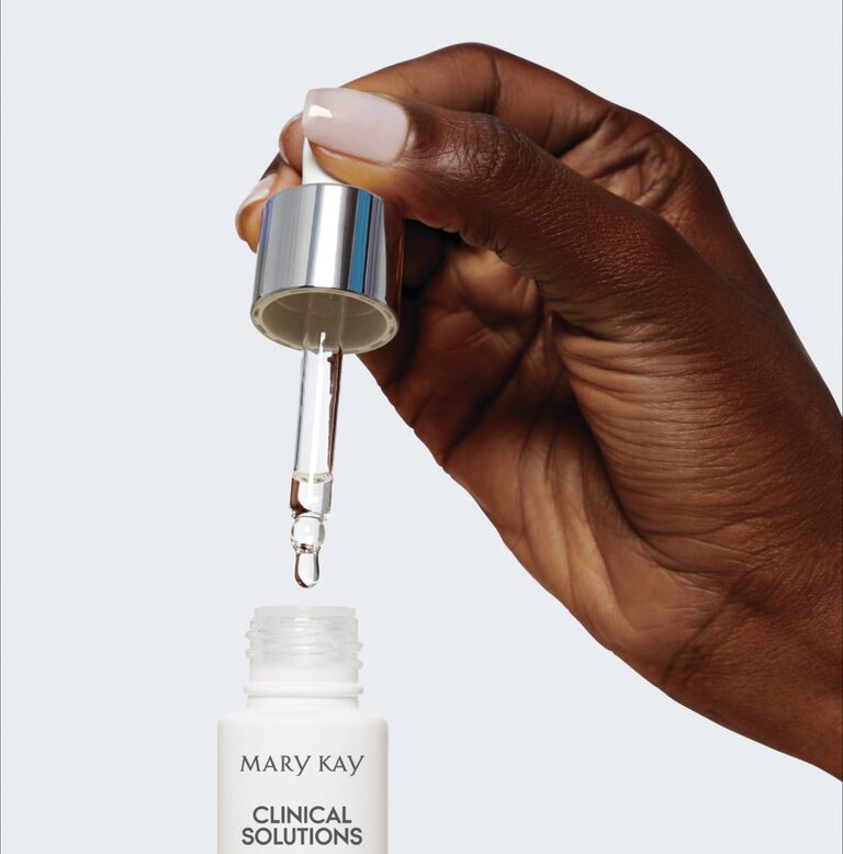 Nahaufnahme einer Hand, die mit der im Drehverschluss enthaltenen Pipette einen Tropfen des Clinical Solution Boosters von Mary Kay aus dem Fl&auml;schchen entnimmt
