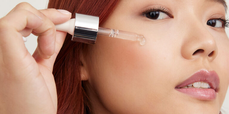 Eine Frau tr&auml;gt mit einer Pipette einen Tropfen eines Mary Kay Clinical Solutions Booster im Gesicht auf