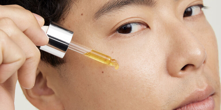 Nahaufnahme von einem Mann, der mit einer Pipette einen Tropfen des Mary Kay Clinical Solutions Booster Vitamin C + Resveratrol Line-Reducer im Gesicht auftr&auml;gt
