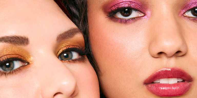 Women showing glitter eyeshadow looks, one wearing gold and one wearing purple