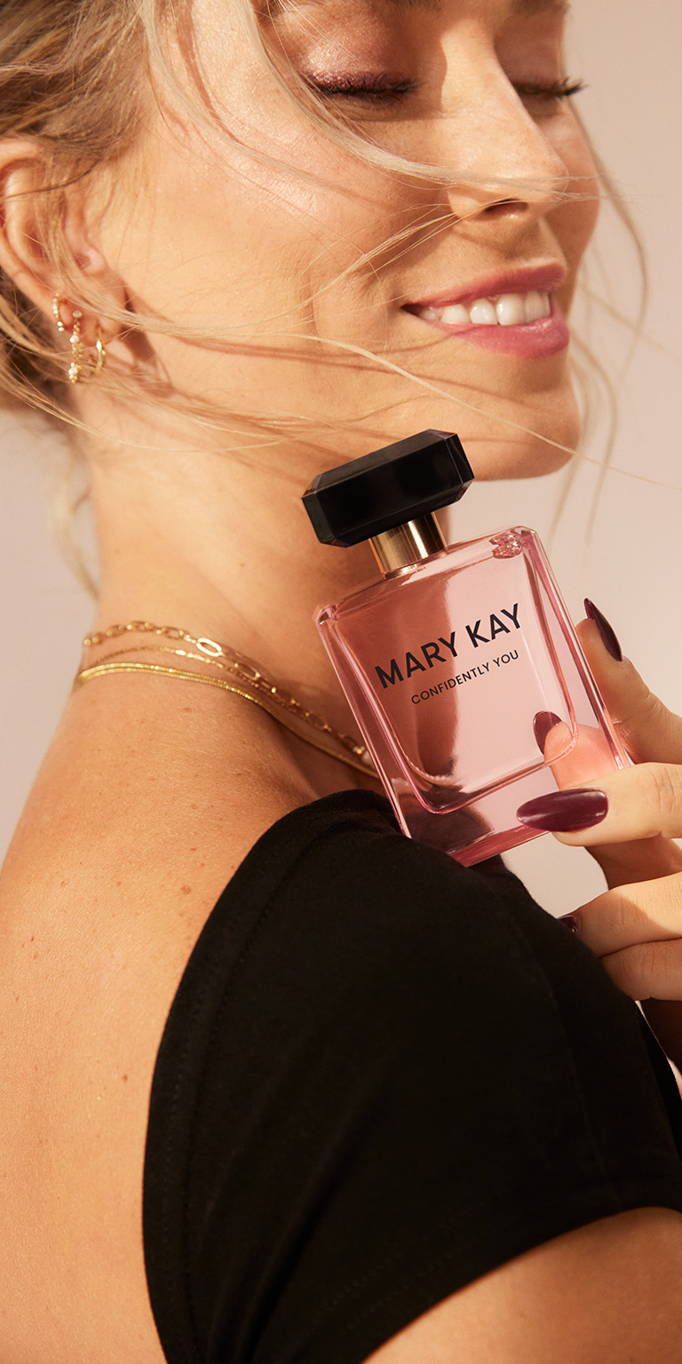 Nahaufnahme einer Frau, die einen Flacon Mary Kay Confidently You Eau de Parfum auf H&ouml;he ihrer Schulter h&auml;lt und die Augen schlie&szlig;t