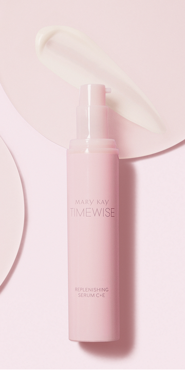Das Mary Kay Replenishing Serum C + E sowie ein Klecks Serum auf einem rosa Untergrund
