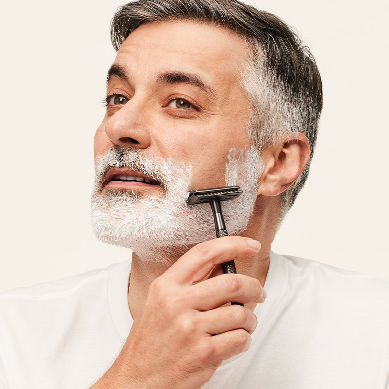 Ein Mann rasiert sich seinen Bart mit MK Men Moisturizing Shave Cream
