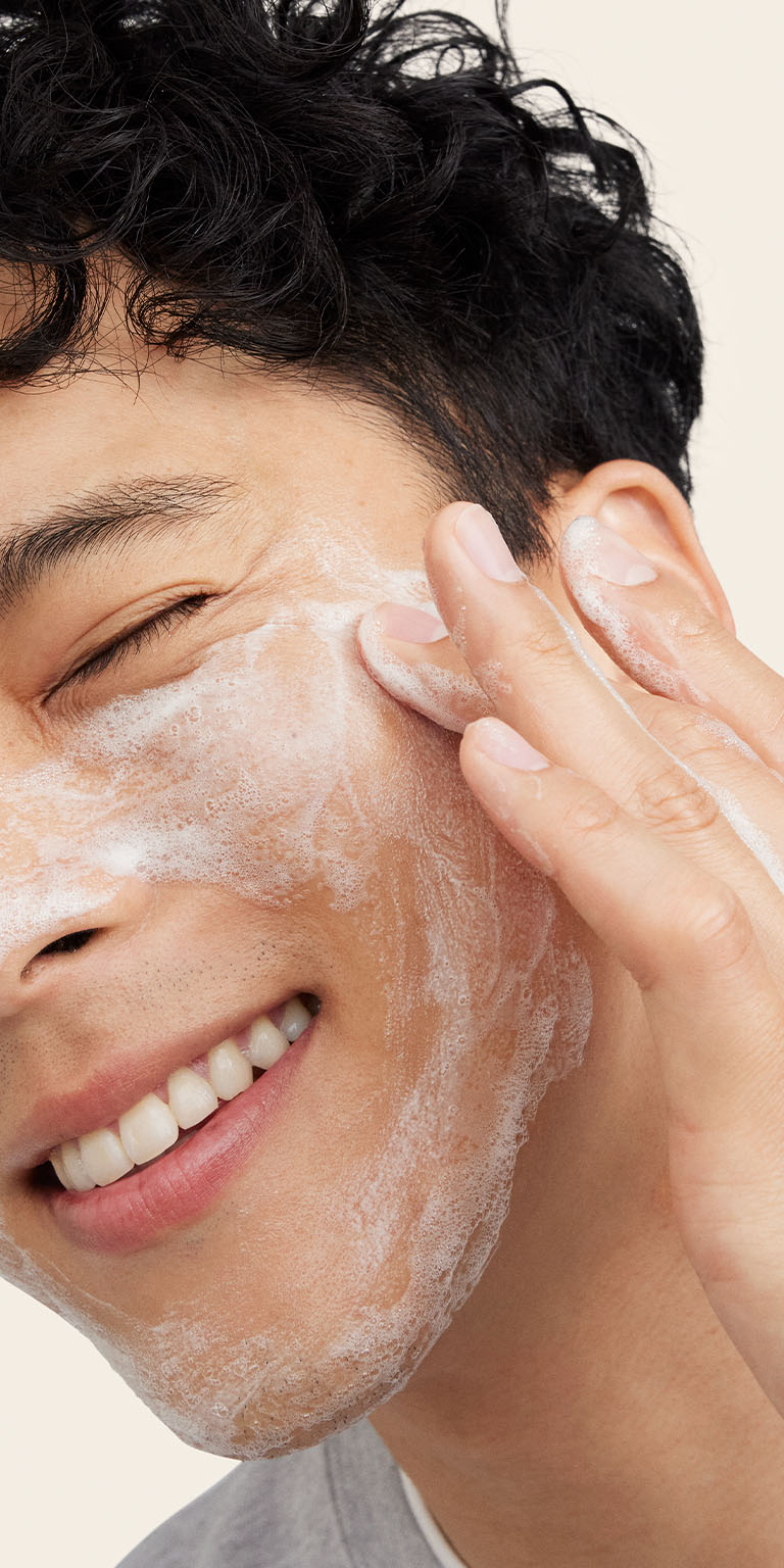 Mann reinigt sein Gesicht mit MK Men Daily Facial Wash