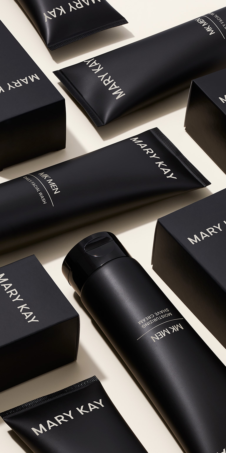 Einige Tuben und Verpackungen der MK Men Moisturizing Shave Cream, MK Men Daily Facial Wash und MK Men Ultimate Moisturizer liegen auf einem hellen Untergrund