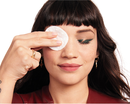Eine Frau hat die Augen geschlossen. Das eine Auge ist noch geschminkt (Eyeliner und Mascara). Das andere Auge wird gerade mit einem Wattepad und Oil-Free Eye Makeup Remover von Mary Kay abgeschminkt.