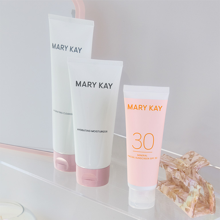 Drei Mary Kay Hautpflegeprodukte auf einer Glasoberf&auml;che: Links der Mary Kay&reg; Hydrating Cleanser, in der Mitte der Mary Kay&reg; Hydrating Moisturizer und rechts der Mary Kay&reg; Mineral Facial Sunscreen LSF 30